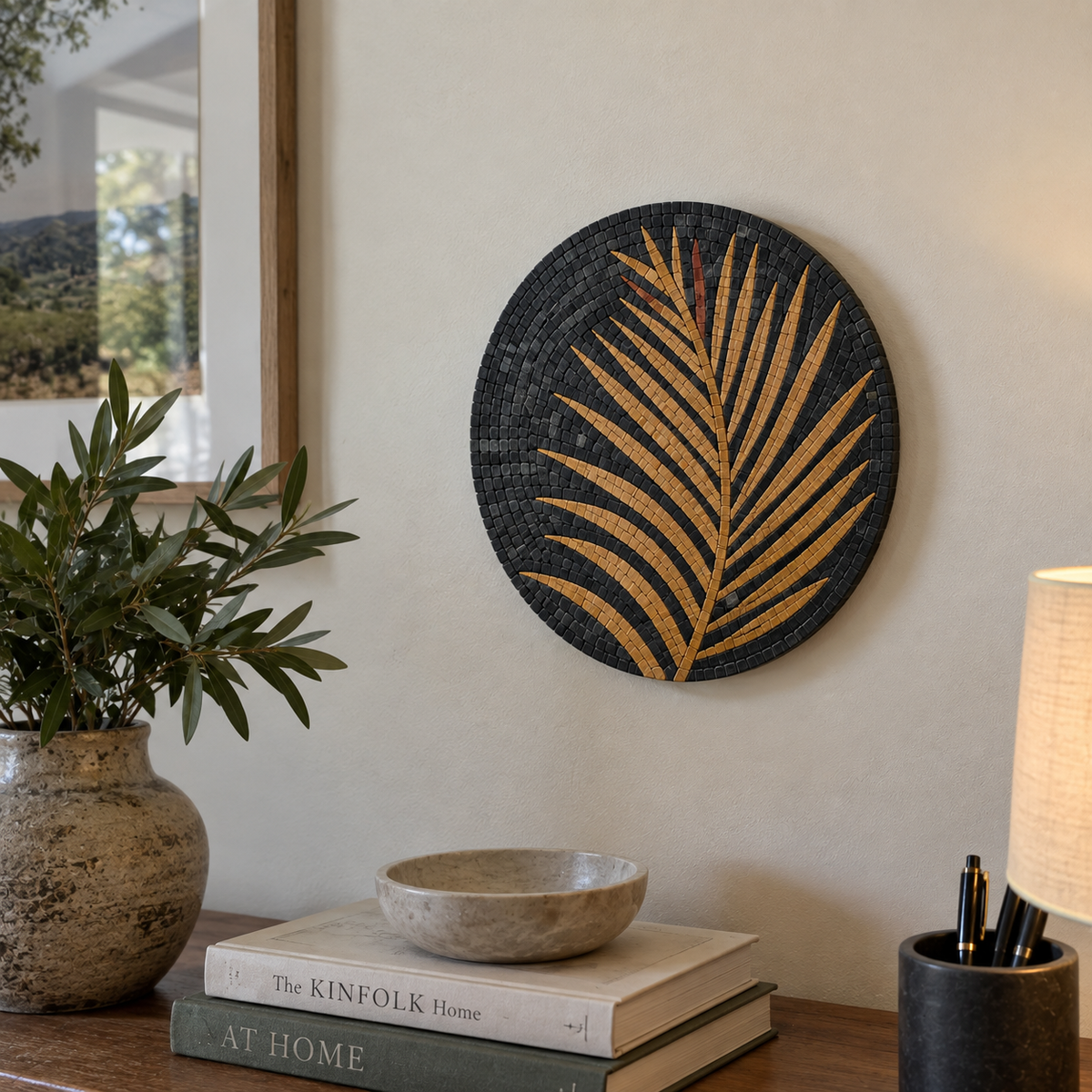 Round stone mosaic wall art, dark base with gold palm frond mosaic.