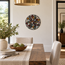 Round stone mosaic wall art with multicolor starburst flower design
