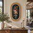 Oval floral mosaic wall hanging with Greek key frame and multicolor bird motif.