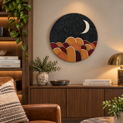 Round black mosaic wall art disc with crescent moon and orange arch mountains