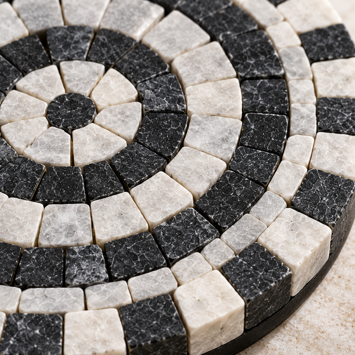 Round stone mosaic coaster with black, white, and ivory tile pattern, 6 in