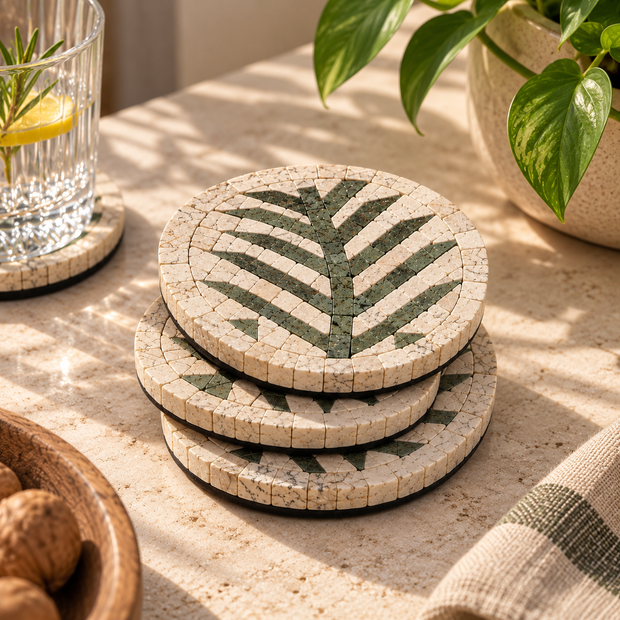 Stack of round ivory-and-green stone mosaic coasters with leaf pattern