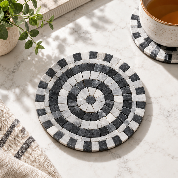 Round black-and-white stone mosaic coaster with circular tile border