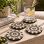 Set of round stone mosaic coasters with concentric black and tan tile medallion centers