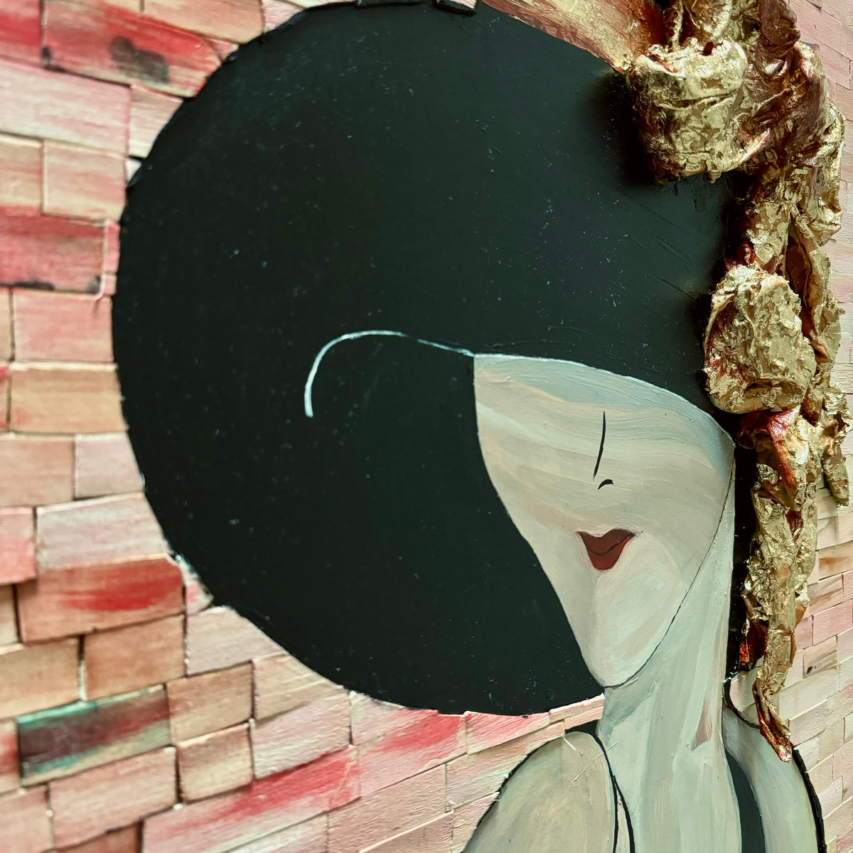 Close-up of the woman’s face and gold hat with black headpiece in mosaic portrait