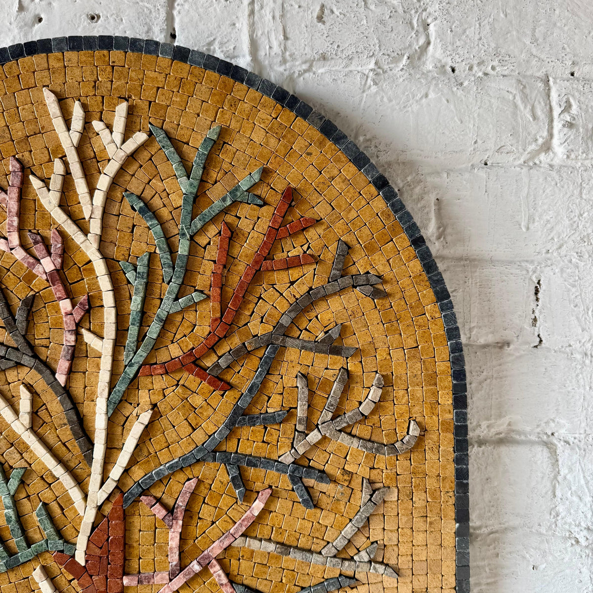 Close-up of arched tree mosaic panel with small glass tile pieces and multicolor trunk