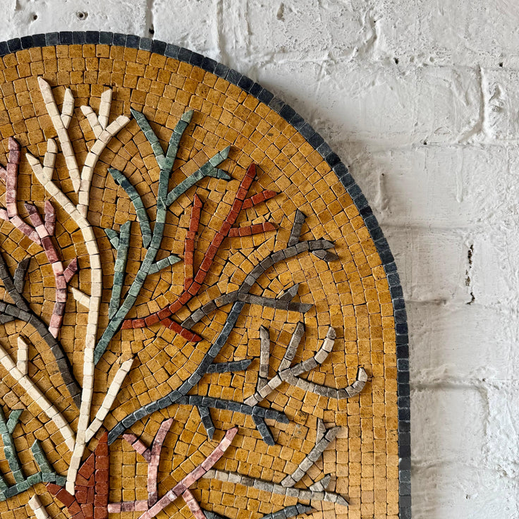 Close-up of arched tree mosaic panel with small glass tile pieces and multicolor trunk