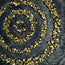 Framed golden spiral mosaic with concentric circles on dark textured background.