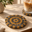 Round stone mosaic coaster with orange and black checker-tile spiral and small center circle.