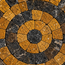 Round stone mosaic coaster with orange and black concentric tile spiral and center medallion.